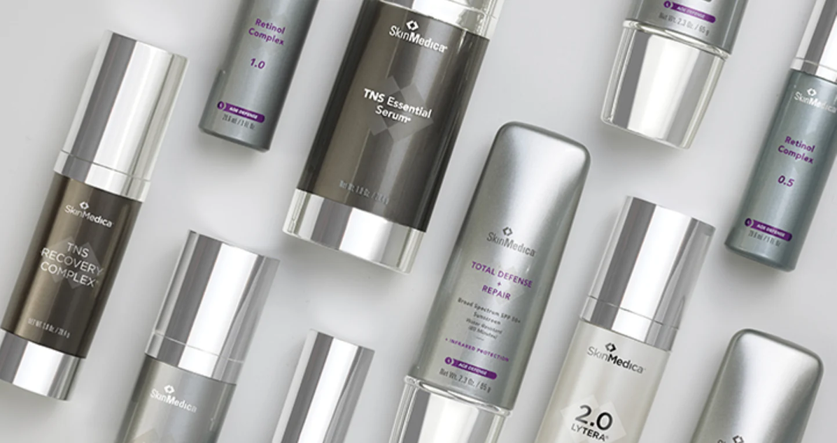 Flat lay of SkinMedica products including TNS Essential Serum, Retinol Complex and Total Defense + Repair